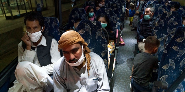 Families evacuated from Kabul, Afghanistan, sit on a bus after they arrived at Washington Dulles International Airport in Chantilly, Va., Saturday, Aug. 21, 2021. (AP Photo/Jose Luis Magana)