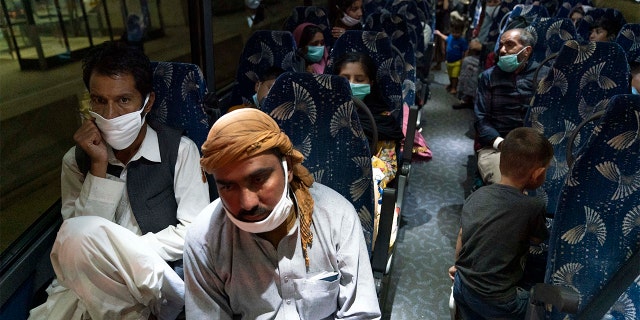 Families evacuated from Kabul, Afghanistan, sit on a bus after they arrived at Washington Dulles International Airport in Chantilly, Va., Saturday, Aug. 21, 2021. (AP Photo/Jose Luis Magana)