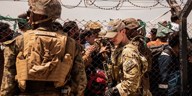 In a photo shared by the U.S. Marine Corps, U.S. military personnel provide assistance during an evacuation at Hamid Karzai International Airport in Kabul, Afghanistan, Sunday, Aug. 22, 2021. 