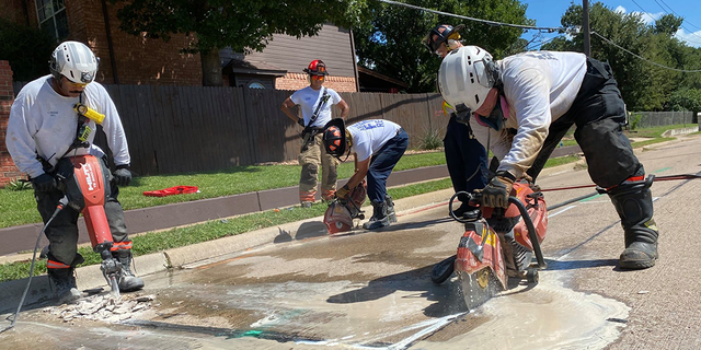 Rescue crews tearing into the street to rescue a dog. 