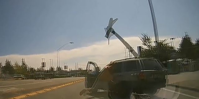 A driver is seen hurling an ax toward another vehicle during a road rage incident in the Seattle area last month. (Q13 FOX of Seattle)