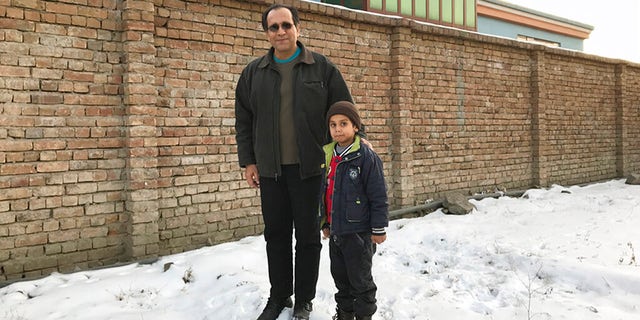 This photo provided by Bahaudin Mujtaba shows Noman Mujtaba, left, and Bahaudin Mujtaba in Kabul, Afghanistan, on Dec. 21, 2017. The boy, now 10 years old, is a distant relative of Mujtaba. (Courtesy of Bahaudin Mujtaba via AP)