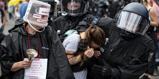 Police arrest a demonstrator at an unannounced demonstration at the Victory Column, in Berlin, Sunday Aug. 1, 2021, during a protest against coronavirus restrictions. (Fabian Sommer/dpa via AP)