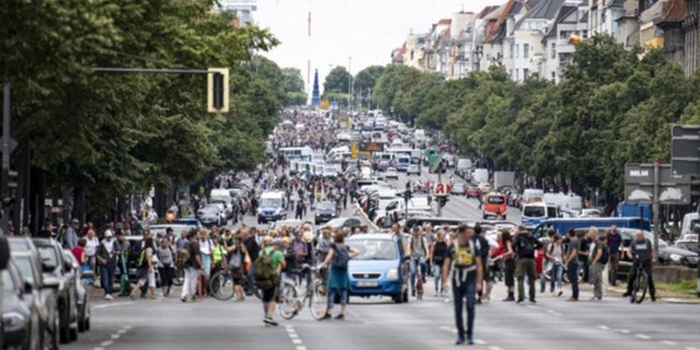 Des manifestants marchent le long de la Bismarckstrasse à Berlin, dimanche 1er août 2021, lors d'une manifestation contre les restrictions liées aux coronavirus.  (Fabian Sommer/dpa via AP)