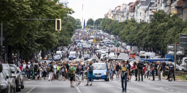 Des manifestants marchent le long de la Bismarckstrasse à Berlin, dimanche 1er août 2021, lors d'une manifestation contre les restrictions liées aux coronavirus.  (Fabian Sommer/dpa via AP)