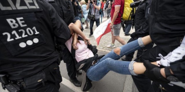 Die Polizei nimmt einen Demonstranten während einer unangekündigten Demonstration an der Siegessäule in Berlin am Sonntag, 1.  (Fabian Sommer/dpa via AP)