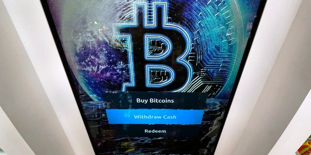 FICHIER - Dans cette photo d'archive du 9 février 2021, le logo Bitcoin apparaît sur l'écran d'affichage d'un guichet automatique de crypto-monnaie au magasin Smoker's Choice à Salem, NH 