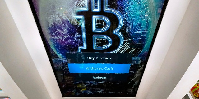 FICHIER - Dans cette photo d'archive du 9 février 2021, le logo Bitcoin apparaît sur l'écran d'affichage d'un guichet automatique de crypto-monnaie au magasin Smoker's Choice à Salem, NH 