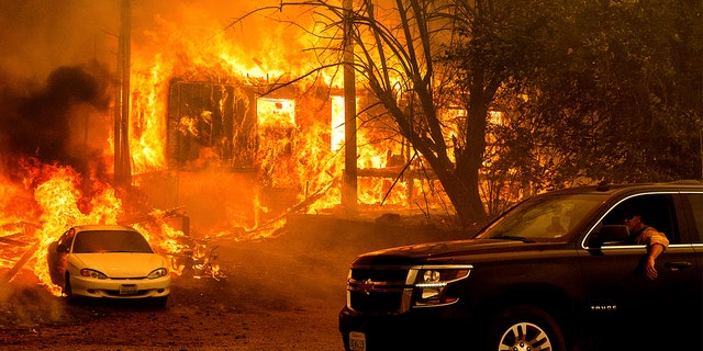 Flames from the Dixie Fire consume a home on Highway 89 south of Greenville on Thursday, Aug. 5, 2021, in Plumas County, Calif.