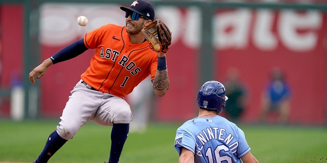 Kansas City Royals' Andrew Benintendi (16) is caught stealing second by Houston Astros shortstop Carlos Correa (1) during the fourth inning of a baseball game Thursday, Aug. 19, 2021, in Kansas City, Mo.