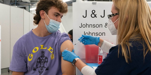 In this July 30, 2021, file photo, Bradley Sharp, of Saratoga, N.Y., gets the Johnson & Johnson vaccine from registered nurse Stephanie Wagner in New York. Sharp needs the vaccination because it is required by his college. Hundreds of college campuses across the country have told students that they must be fully vaccinated against COVID-19 before classes begin in a matter of weeks. (AP Photo/Mark Lennihan, File)