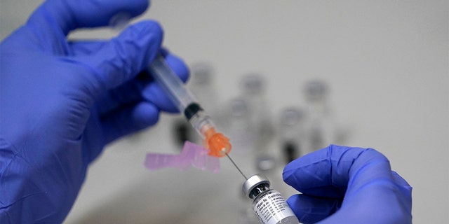 FILE - A pharmacy technician loads a syringe with Pfizer's COVID-19 vaccine, Tuesday, March 2, 2021, at a mass vaccination site at the Portland Expo in Portland, Maine. (AP Photo/Robert F. Bukaty)