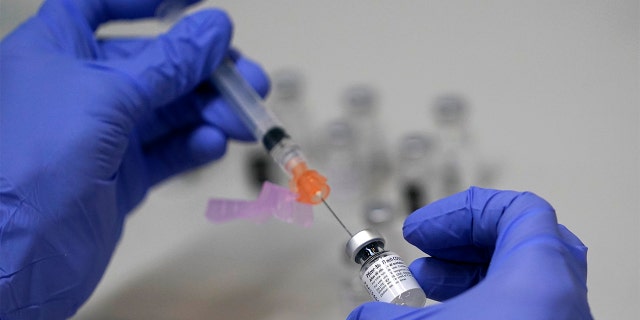 FILE - A pharmacy technician loads a syringe with Pfizer's COVID-19 vaccine, Tuesday, March 2, 2021, at a mass vaccination site at the Portland Expo in Portland, Maine. (AP Photo/Robert F. Bukaty)