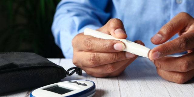 young man hand measuring diabetic on table