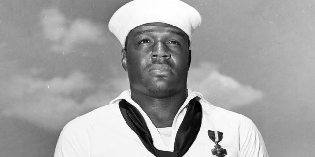 After being presented with the Navy Cross by Admiral Chester W. Nimitz, on board USS Enterprise (CV-6) at Pearl Harbor, 27 May 1942. The medal was awarded for heroism on board USS West Virginia (BB-48) during the Pearl Harbor Attack, 7 December 1941. Official U.S. Navy Photograph, now in the collections of the National Archives.