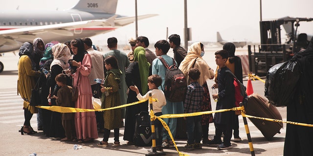 Afghan citizens board a U.S. military plane leaving Afghanistan. 