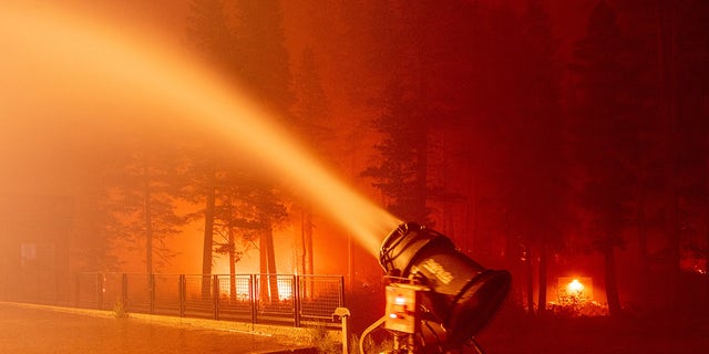 A snow gun sprays water at the Sierra-at-Tahoe Resort during the Caldor fire in Twin Bridges, California on August 30, 2021. 