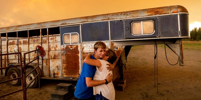 Hunter McKee hugs Dawn Garofalo after helping her evacuate her horses to the edge of Lake Almanor as the Dixie Fire approaches Chester, Calif, on Tuesday, Aug. 3, 2021. Officials issued evacuation orders for the town earlier in the day as dry and windy conditions led to increased fire activity.