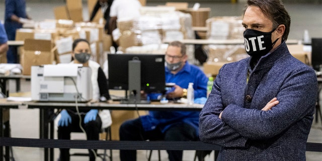 FILE - In this Wednesday, Nov. 25, 2020 file photo, Fulton County Georgia. election chief Richard Barron talks to reporters as workers scan ballots during a presidential recount in Atlanta. (AP Photo/Ben Gray, File)