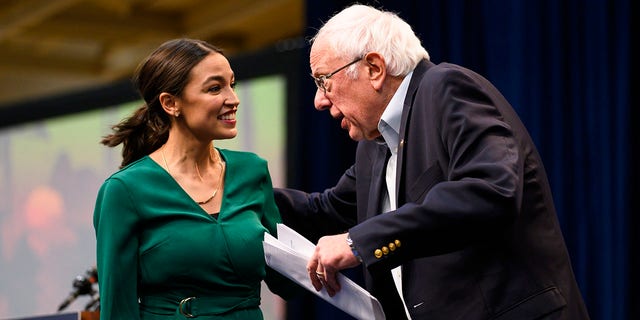 Rep. Alexandria Ocasio-Cortez is joined on stage by Sen. Bernie Sanders during the Climate Crisis Summit at Drake University on Nov. 9, 2019 in Des Moines, Iowa.