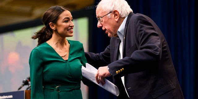 DES MOINES, IA - NOVEMBER 09: U.S. Rep. Alexandria Ocasio-Cortez (D-NY) is joined on stage by Democratic Presidential candidate Bernie Sanders (I-VT) during the Climate Crisis Summit at Drake University on November 9, 2019 in Des Moines, Iowa. Sanders, Ocasio-Cortez, and author Naomi Klein spoke about the current state of climate change in relation to U.S. policy. 