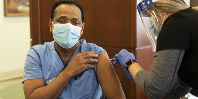 A healthcare worker receives the Pfizer-BioNTech Covid-19 vaccine at SSM Health St. Anthony Hospital in Oklahoma City, Oklahoma, December 16, 2020 (Getty Images)