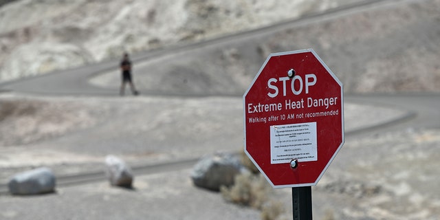 A warning sign alerts visitors of heat dangers at Zabriskie Point on July 11, 2021 in Death Valley National Park, California. (Getty Images)