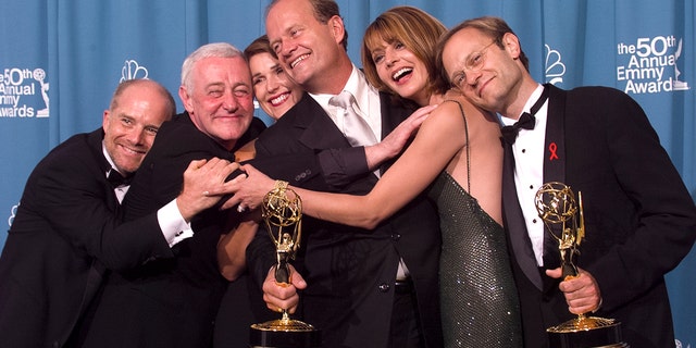 Emmy-winners, actors Kelsey Grammer (center) and David Hyde Pierce (R) are joined by fellow 'Frasier' cast members actors Jane Leeves (2nd R), Peri Gilpin, John Mahoney (2nd L) and James Burrows (L) for a group-hug backstage at the 50th Annual Emmy Awards, on September 13, 1998 in Los Angeles, California. 