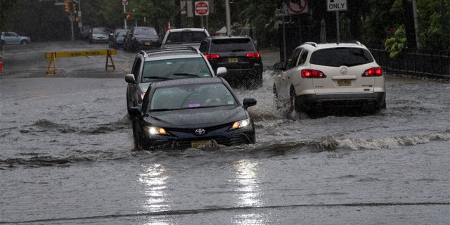 A car drives through a flooded street as Tropical Storm Henry approaches in Hoboken, New Jersey, August 22, 2021.