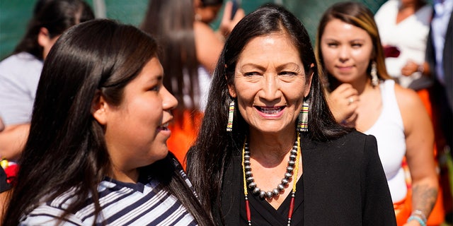 FILE - In this July 14, 2021, ファイル写真, Interior Secretary Deb Haaland meets with young people from the Rosebud Sioux Tribe after a ceremony of the disinterred remains of nine Native American children who died more than a century ago while attending a government-run school in Pennsylvania.   (AP写真/マ�ファイルローク, File)