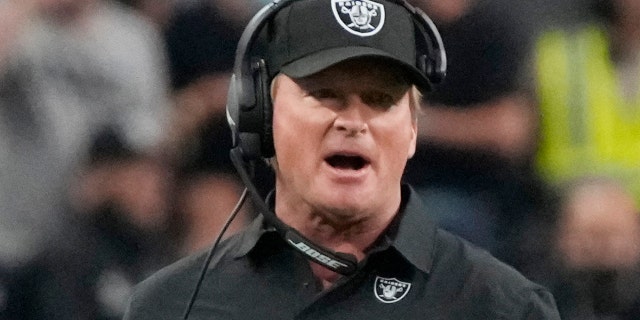 Las Vegas Raiders head coach Jon Gruden, left, speaks with an official during the first half of an NFL preseason football game against the Seattle Seahawks, Saturday, Aug. 14, 2021, in Las Vegas.