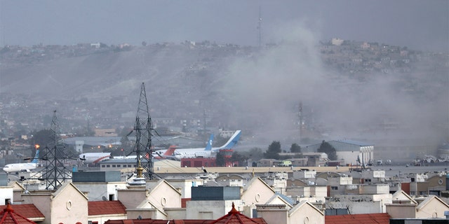 Smoke rises from explosion outside the airport in Kabul, 아프가니스탄, 목요일, 8월. 26, 2021. The explosion went off outside Kabul’s airport, where thousands of people have flocked as they try to flee the Taliban takeover of Afghanistan. Officials offered no casualty count, but a witness said several people appeared to have been killed or wounded Thursday. (AP Photo/Wali Sabawoon)
