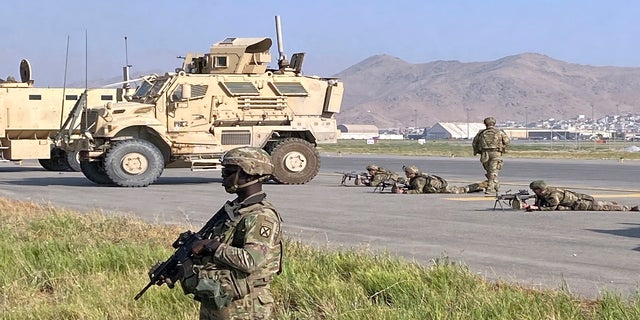 U.S soldiers stand guard along a perimeter at the international airport in Kabul on Monday. 