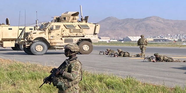 U.S soldiers stand guard along a perimeter at the international airport in Kabul on Monday.