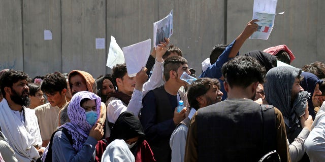 수백명의 사람들, some holding documents, gather near an evacuation control checkpoint on the perimeter of the Hamid Karzai International Airport, in Kabul, 아프가니스탄, 목요일, 8월. 26, 2021. Western nations warned Thursday of a possible attack on Kabul's airport, where thousands have flocked as they try to flee Taliban-controlled Afghanistan in the waning days of a massive airlift. Britain said an attack could come within hours.