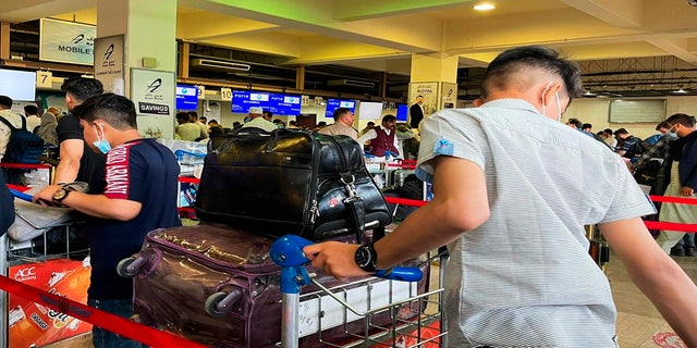 Пасажири, які намагаються покинути міжнародний аеропорт Кабула на тлі нападу талібів, чекають у черзі в п'ятницю.  (AFP)