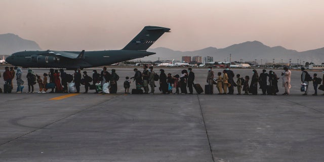 In this image provided by the U.S. Marine Corps, evacuees wait to board a Boeing C-17 Globemaster III, at Hamid Karzai International Airport, Kabul, Afghanistan, on Monday. (AP/Sgt. Isaiah Campbell/U.S. Marine Corps)