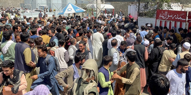 People try to get into Hamid Karzai International Airport in Kabul, Afghanistan August 16, 2021. (REUTERS/Stringer)