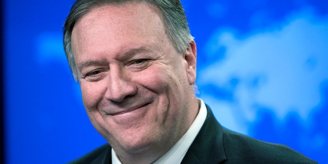 Former Secretary of State Mike Pompeo smiles as he speaks with reporters at the State Department in Washington. 