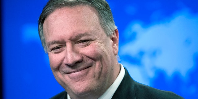 Former Secretary of State Mike Pompeo smiles as he speaks with reporters at the State Department in Washington. 