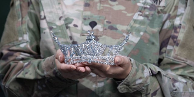 Army Spc. Maura Spence holds her crown.