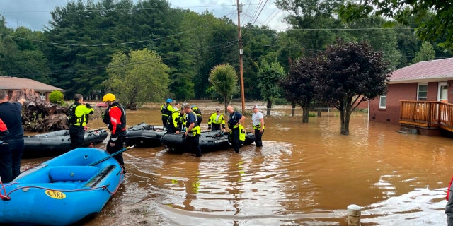 In this image provided by New Hanover County Fire Rescue, members of North Carolina’s Task Force 11, based in New Hanover County, are shown during rescue efforts in Canton, 北卡, 星期二, 八月. 17, 2021. Authorities said that dozens of water rescues were performed after the remnants of Tropical Storm Fred dumped rain on the mountains of North Carolina. (New Hanover County Fire Rescue via AP)