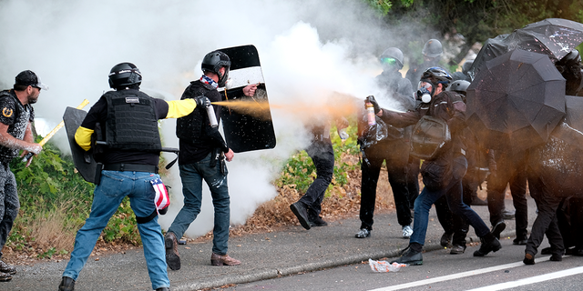 Anggota kelompok sayap kanan Proud Boys dan pengunjuk rasa anti-fasis saling menyemprotkan gada beruang selama bentrokan antara kelompok yang berlawanan secara politik pada Minggu, 22 Agustus 2021, di Portland, Ore (AP Photo/Alex Milan Tracy)