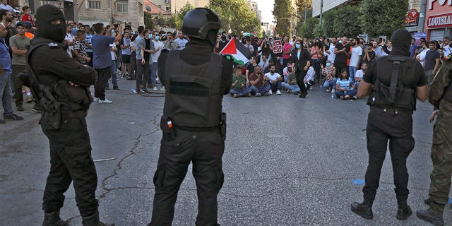 Palestinian security forces deploy as demonstrators rally in Ramallah city in the occupied West Bank on July 3, 2021.