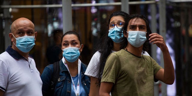 People wear a face masks in midtown Manhattan in New York on July 29, 2021. 