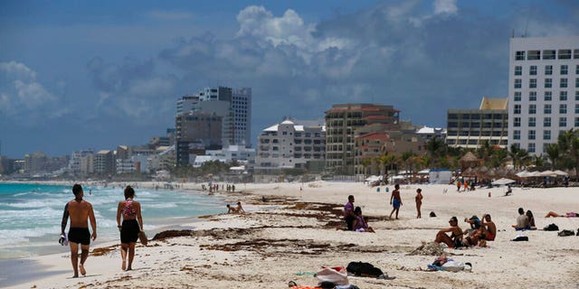 Tourists enjoy the beach in Cancun, Quintana Roo State, Mexico, Wednesday, Aug. 18, 2021. 