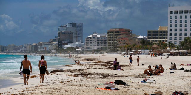 Tourists enjoy the beach in Cancun, Quintana Roo State, Mexico, Wednesday, Aug. 18, 2021. 