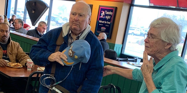 Roy Blackburn and his wife, Carol, stand up at a Pizza Street in Olathe, Kanasas when a group of middle school students sing the national anthem to them. 