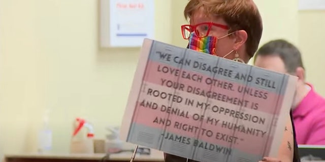 Charlotte McConnell holding up a sign quoting James Baldwin at the Aug. 10 Loudoun County School Board meeting.
