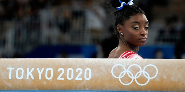 Simone Biles prepares to perform on the balance beam